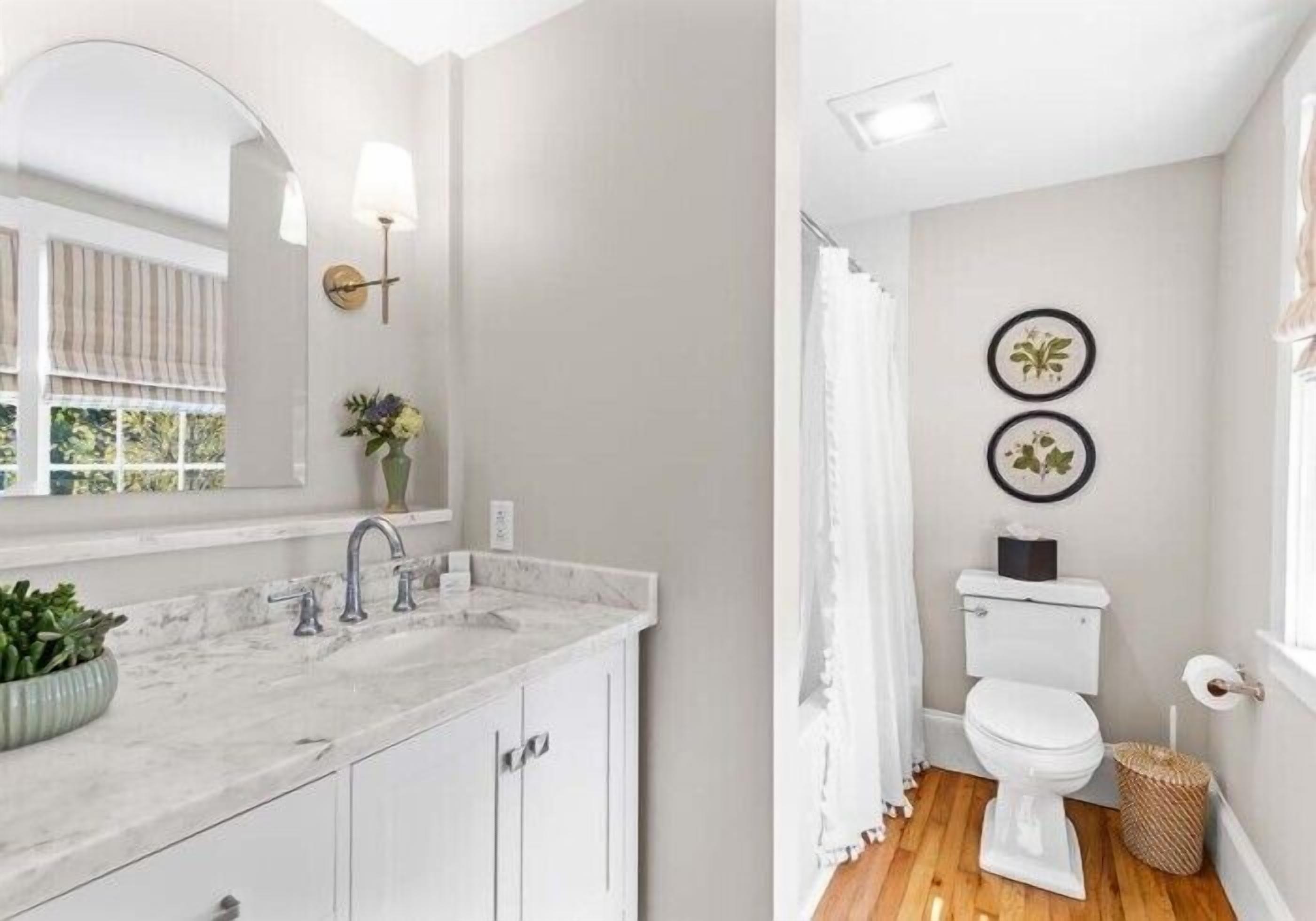 A bathroom with a white toilet, a sink with a marble countertop, and a shower curtain.