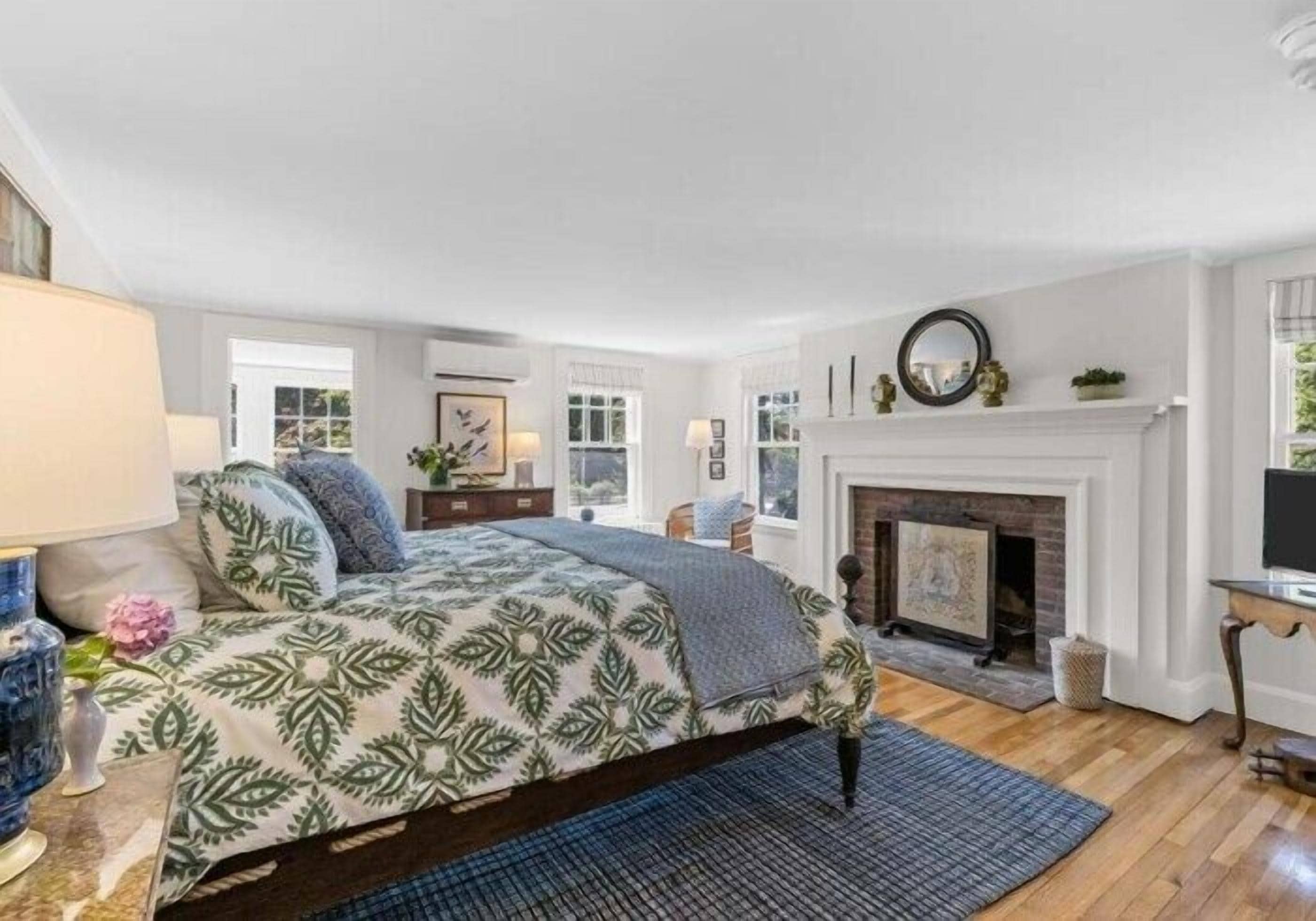 Une chambre à coucher avec un lit, une cheminée et une fenêtre.