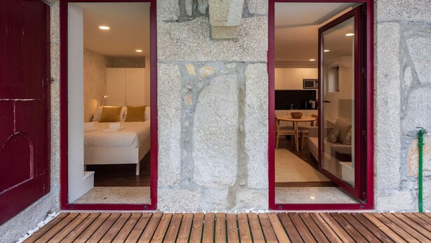 A stone facade with two open doors leading to a bedroom and a kitchenette. - Central Porto Hideaway with Sunny Terrace by Lisbeyond (Porto)