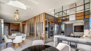 A modern kitchen with a central island, built-in appliances, and a mezzanine level. - Sophisticated Stay 200m From Praia Brava - EHI (Itajai)