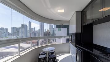 A modern kitchen with a large window overlooking a cityscape.