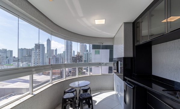A modern kitchen with a large window overlooking a cityscape.