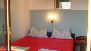 A room with a bed, a nightstand, a lamp, and a painting on the wall. - Apartments A&N Pakoštane - One Bedroom Apartment with Sea View and Balcony (A1) (Pakoštane)