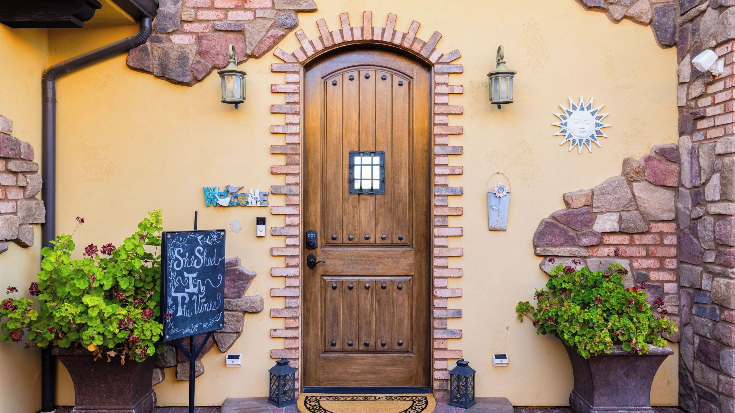 A wooden door with a small window, a welcome sign, and a chalkboard sign.