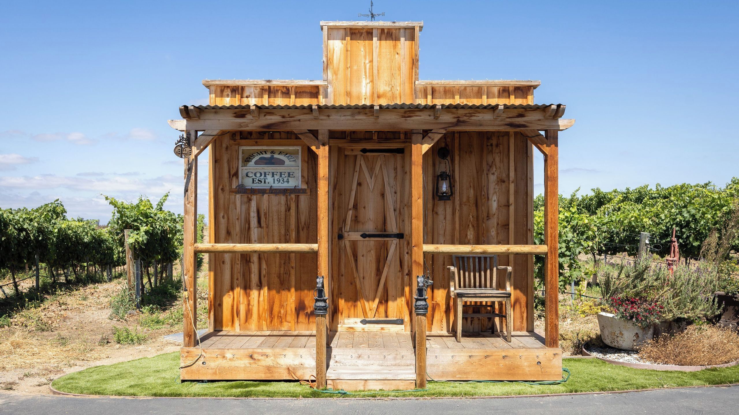 Un edificio de madera rústica con un letrero que dice 'Bright & Early Coffee EST. 1934' y un letrero que dice 'Bienvenido'.