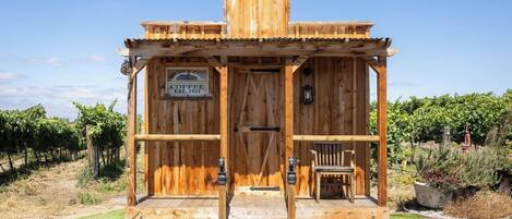 Un edificio de madera rústica con un letrero que dice 'Bright & Early Coffee EST. 1934' y un letrero que dice 'Bienvenido'.