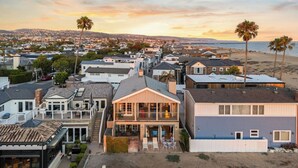 A residential area with houses, a beach, and a hilly backdrop. - Oceanfront Home Walk to Balboa Pier + Scenic Views Balboa Peninsula Point by Avantstay (Newport Beach)