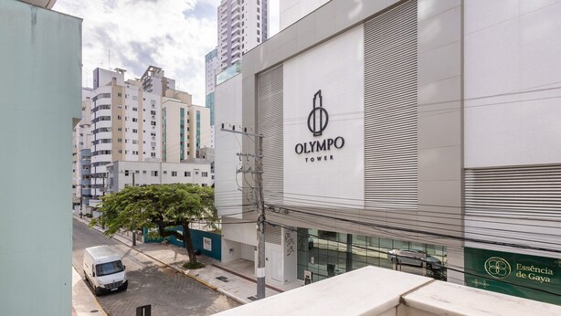 A modern building with a prominent "Olympo Tower" sign, surrounded by other high-rise buildings. - Apt in BC Center w Balcony 260m From Beach Elo0207 (Balneário Camboriú)