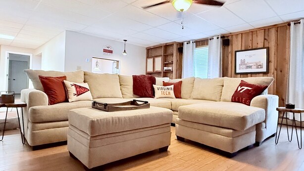 Ein Wohnzimmer mit Ecksofa, Couchtisch und Deckenventilator.