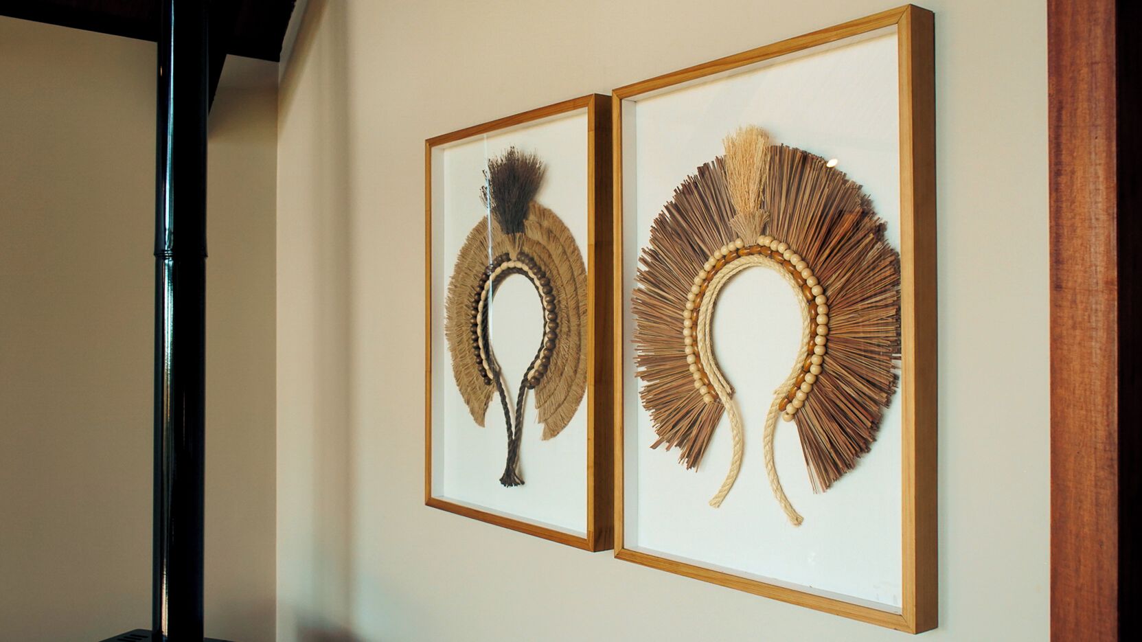 Two framed wall art pieces with feather and bead designs.