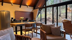 Una cocina moderna con refrigerador incorporado, mesa de comedor de madera y sillas.