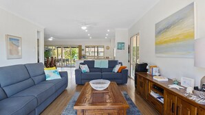 A spacious living room with two sofas, a coffee table, and a wooden cabinet. - Jacks Corner - Moments to the beach, free wifi, pet friendly - wont be disapointed! (Normanville)