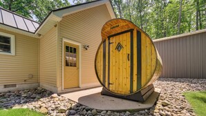 Uma sauna com porta de madeira e um pequeno alpendre.