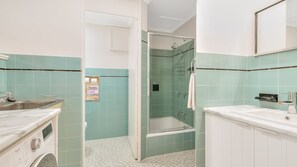 Un baño con ducha, lavamanos e inodoro.