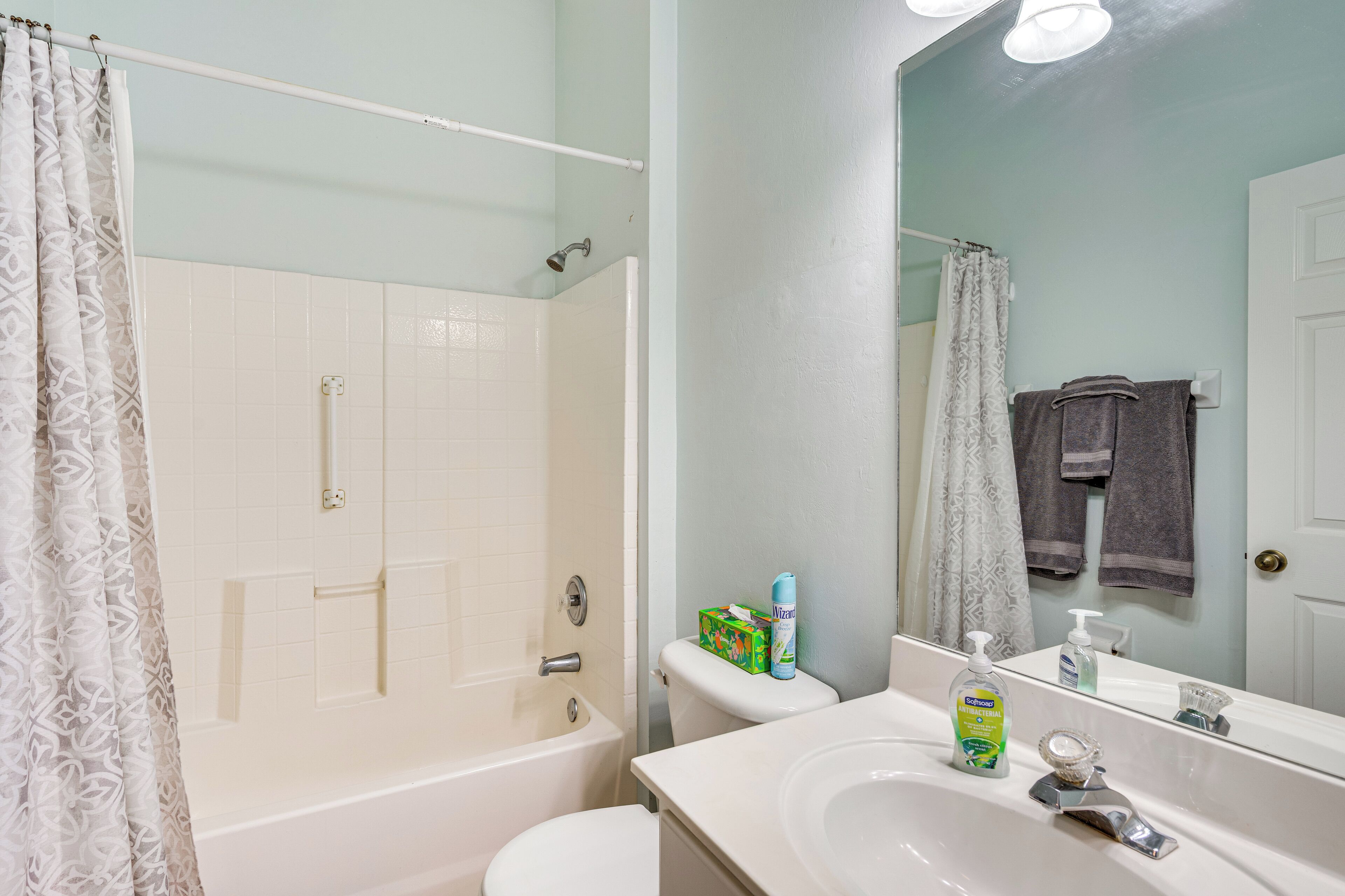 Ein Badezimmer mit Badewanne, Toilette, Waschbecken und Spiegel.