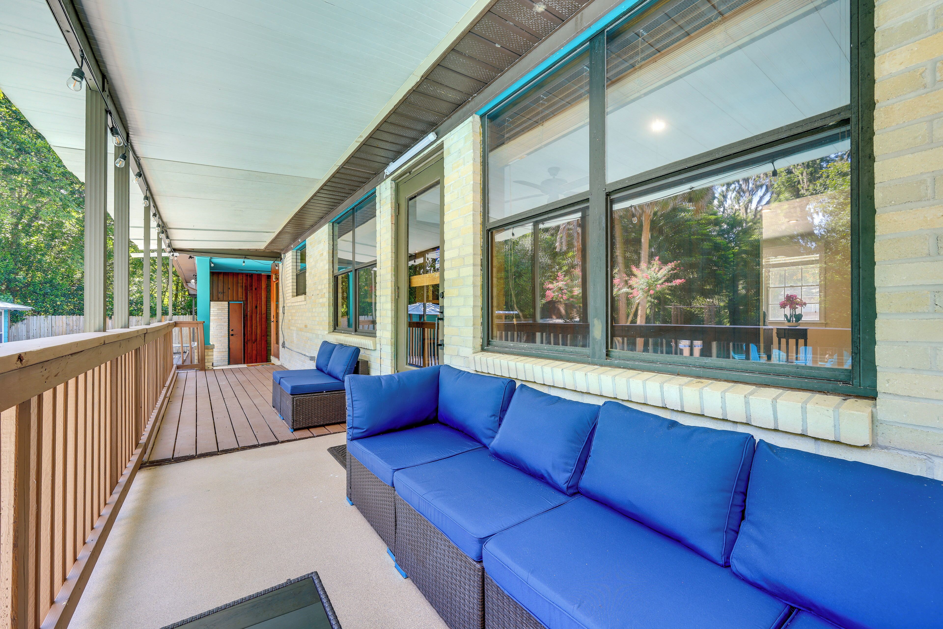 A covered outdoor seating area with a built-in sofa and a wooden deck.