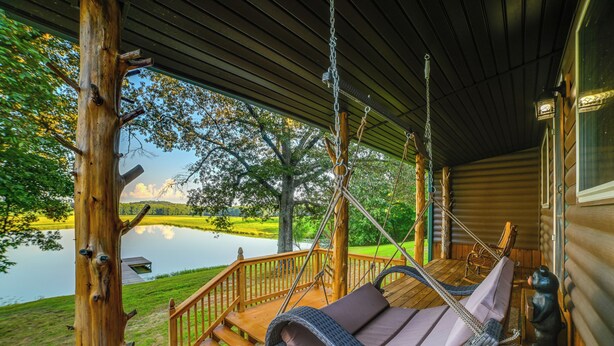 A wooden deck with a hanging chair and a view of a lake. - Private Lake & Dock: Log Cabin, 2 Mi to Clay! (Clay)