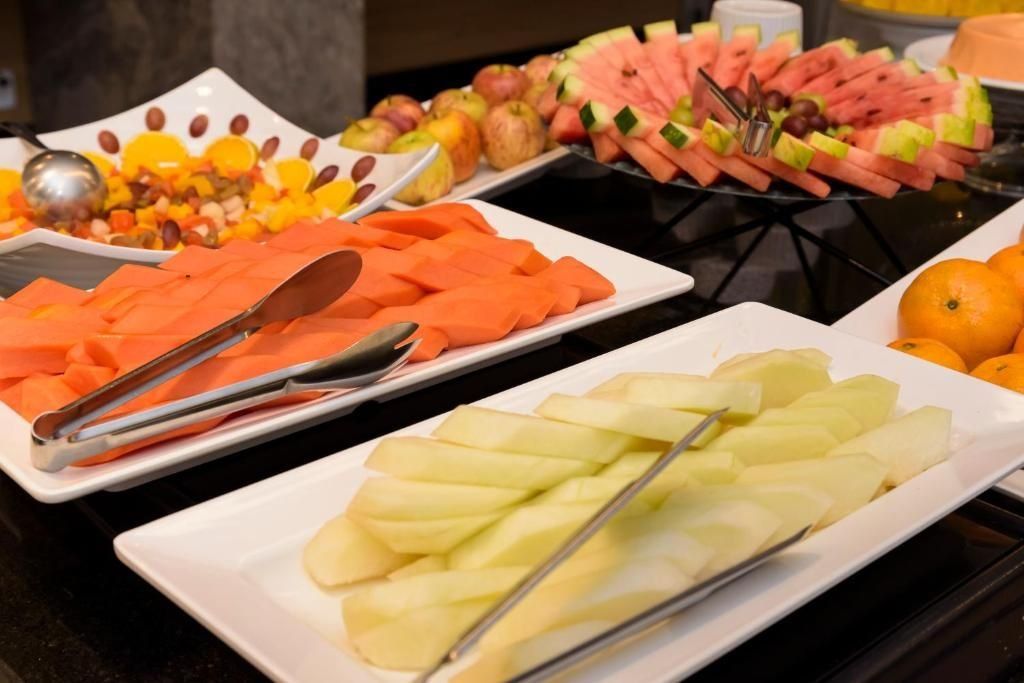A buffet with various fruits and vegetables, including watermelon, apples, and carrots.