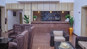 Eine Lobby mit Sitzgelegenheiten, einer Rezeption und einer Bar.