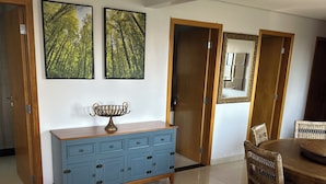 A dining area with a wooden table and chairs, a blue cabinet with drawers, and two framed pictures on the wall. - Make yourself at home (Goiania)