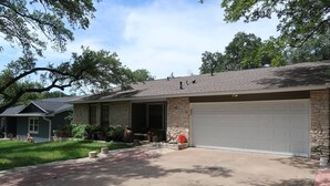 A two-story house with a stone facade, a garage, and a covered porch.