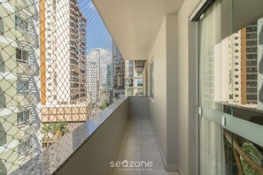 A narrow balcony with a chain-link fence, glass doors, and a view of adjacent buildings. - 3BR Apt w/ sea View in BC Downtown Eoa0803 (Balneário Camboriú)