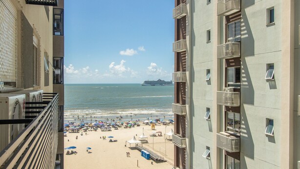 Un hotel sulla spiaggia con balconi affacciati sul mare e sulla spiaggia.