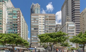 Un paysage urbain avec de grands immeubles, un sol sablonneux et des arbres.