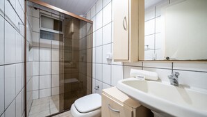 A bathroom with a glass-enclosed shower, a toilet, a sink, and a mirror. - Apt in BC 4min fr th Beach and Av Atlantica Epf202 (Balneário Camboriú)