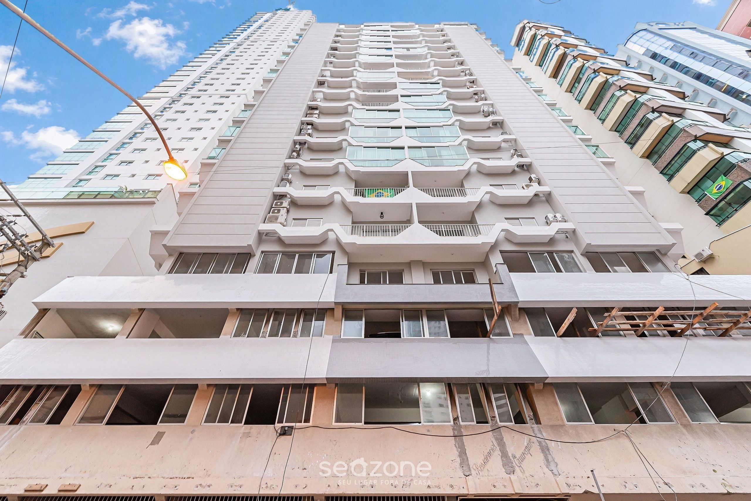A high-rise building with multiple balconies and large windows.