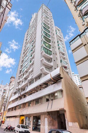 Un immeuble à plusieurs étages doté d’une architecture moderne, avec des balcons et de grandes fenêtres.