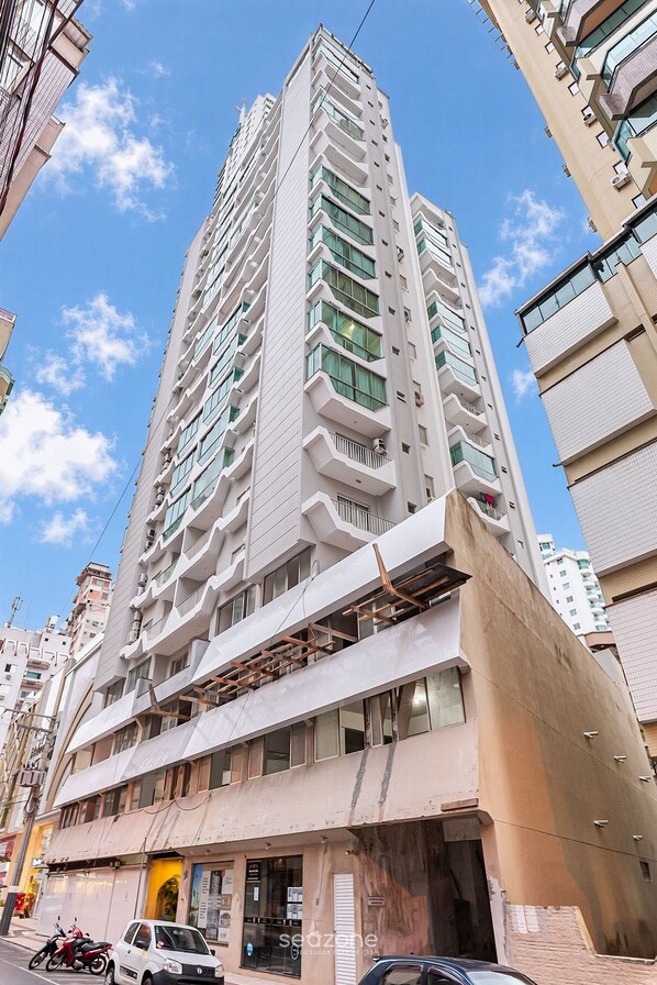 A multi-story building with a modern architectural design, featuring balconies and large windows.
