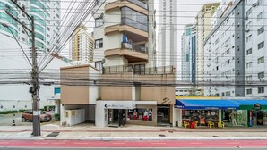 Un immeuble à plusieurs étages avec un magasin au rez-de-chaussée et une marquise bleue.