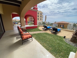 A resort patio with outdoor seating, a pool area, and a view of the ocean. - Charming 3-bedroom villa with AC, all inclusive resort in Cabo San Lucas. (El Paraje)