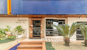 A building with a blue tiled facade, a sign reading "Residencial Valdeli 814", and a well-maintained entrance with steps and potted plants. - 3BR Apt w/ BBQ 80m From Beach Erv0101 (Balneário Camboriú)