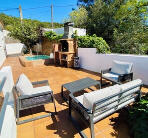 A patio with outdoor furniture, a barbecue grill, and a swimming pool.