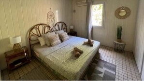 Un dormitorio con cama, mesita de noche, lámpara y un atrapasueños en la pared.