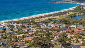 Une zone résidentielle côtière comprenant des maisons, des routes et une plage.