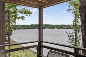 A wooden deck with a view of a lake and distant hills.