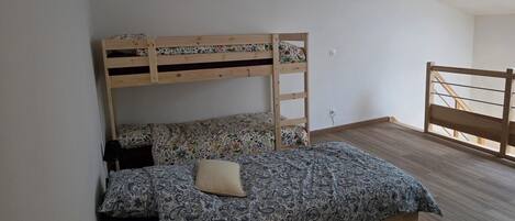 Un lit superposé avec une couvre-lit à motifs floraux et un seul oreiller.