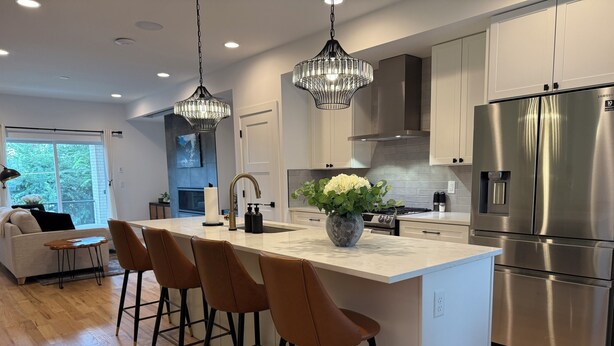 A modern kitchen with a central island, stainless steel appliances, and pendant lighting.