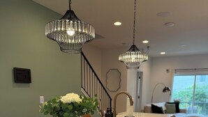 A modern kitchen with a central island, stainless steel appliances, and pendant lighting.