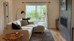 A modern living room with a sofa, a coffee table, and a TV.