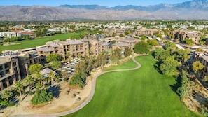 Un campo de golf con un club de campo y edificios residenciales.