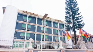 A multi-story hotel with a name sign, multiple flags, and a stone facade. - Kenbrill Hyatt Hotel (Benin City)