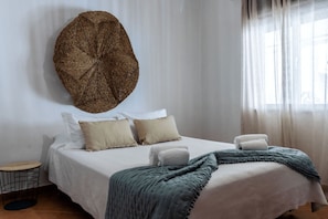 A neatly made bed with pillows, a blanket, and a wall-mounted decorative item.