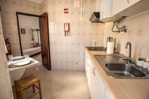Eine kleine Küche mit Spüle, Holz Arbeitsplatte und einem kleinen Hocker.