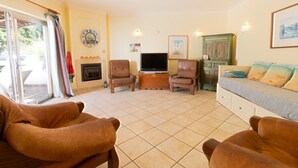 Ein Wohnzimmer mit Kamin, Fernseher und einer Couch.