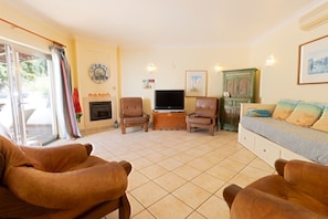 A living room with a fireplace, a television, and a sofa.