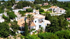 A residential area with houses, some with tiled roofs, surrounded by greenery and trees. - Casa do Mar by Urban Beach Rentals (Vale Centianes - Carvoeiro -Lagoa)